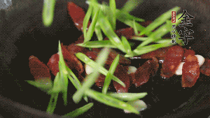 先后下香腸片、四季豆絲均勻翻炒，加適量清水燜煮一下。