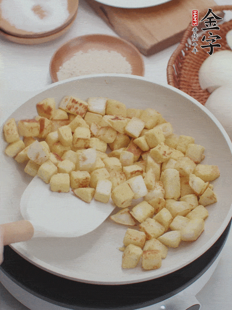 起鍋熱油，倒入饅頭丁，小火煎至蛋液凝固定型再翻面，饅頭丁部煎至金黃時盛起待用。