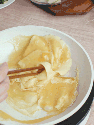 油6成熱時，下雞蛋液，邊緣凝固時翻拌成塊狀。